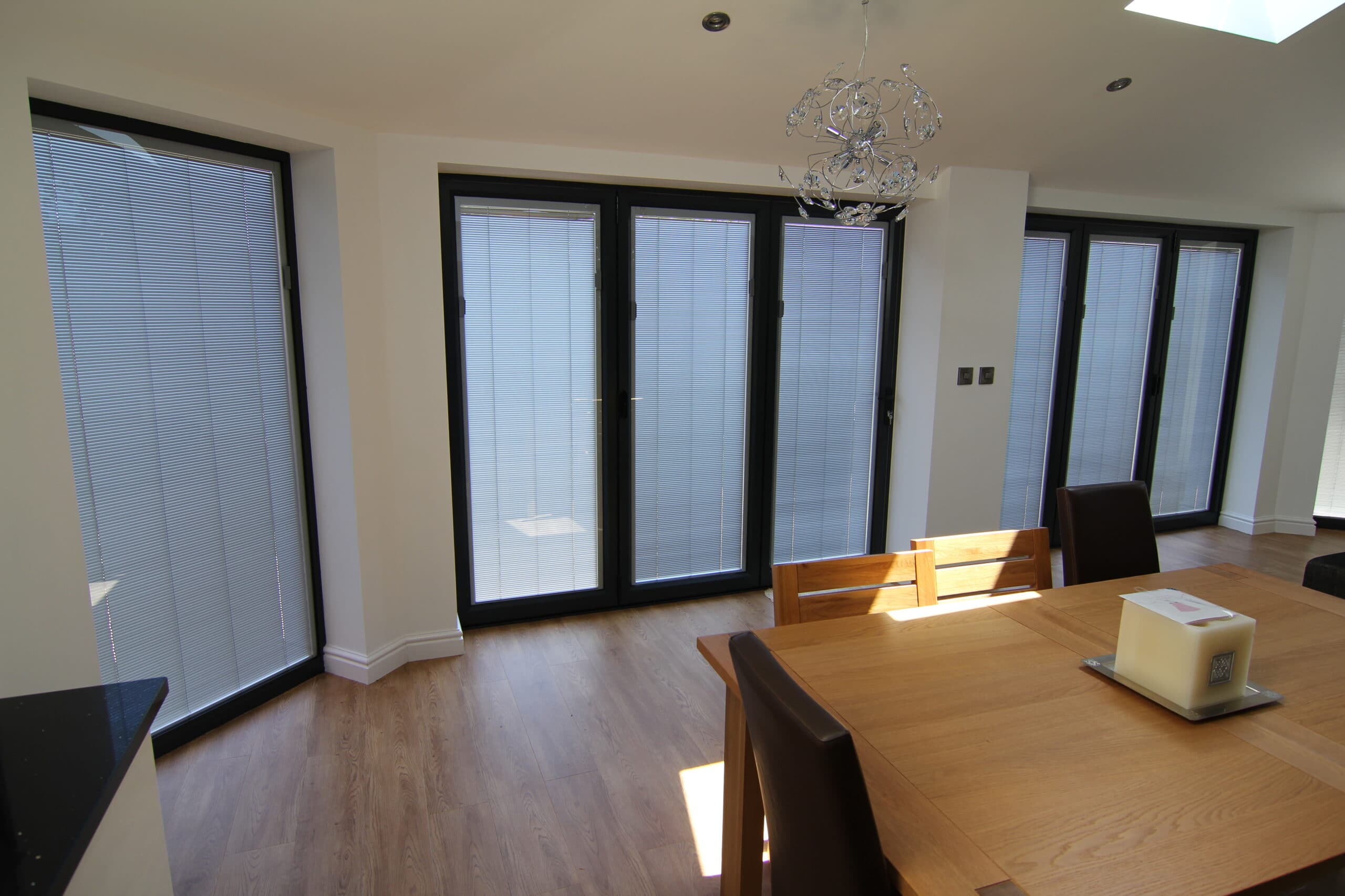 new bifolding doors with closed blinds in a dining room